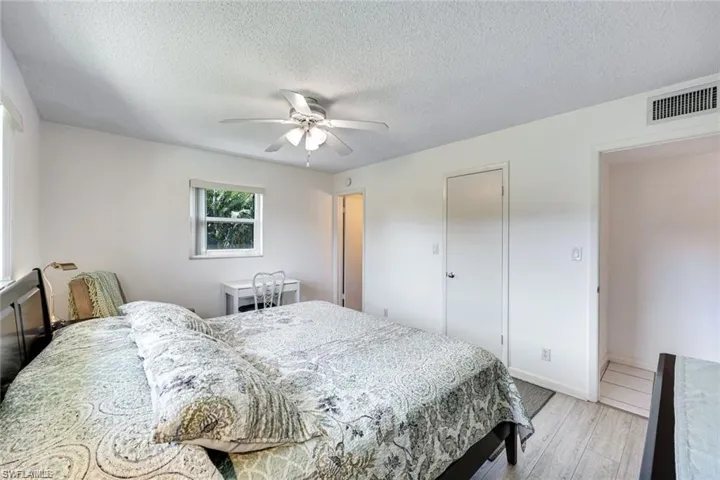 Bedroom featuring wood finished floors, a textured ceiling, a ceiling fan, and a closet