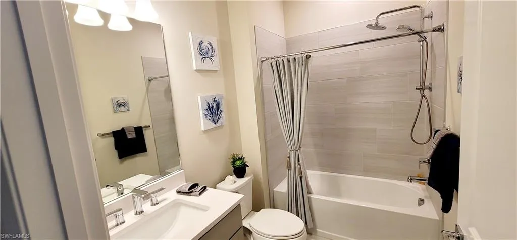 Full bathroom featuring vanity, shower / bath combo, and toilet