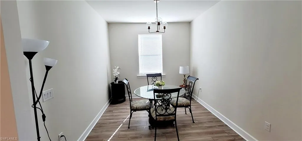 Dining space with hardwood / wood-style flooring and a chandelier