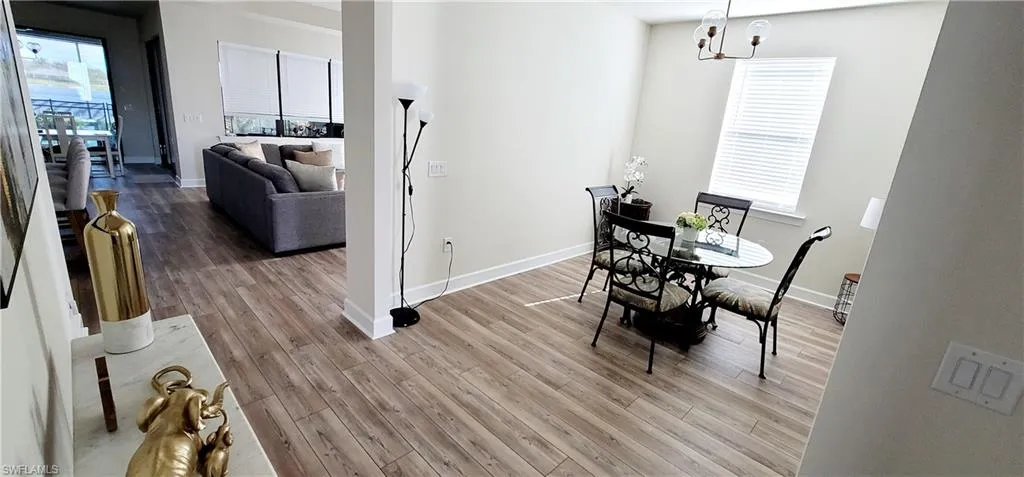 Dining room with wood-type flooring and a notable chandelier