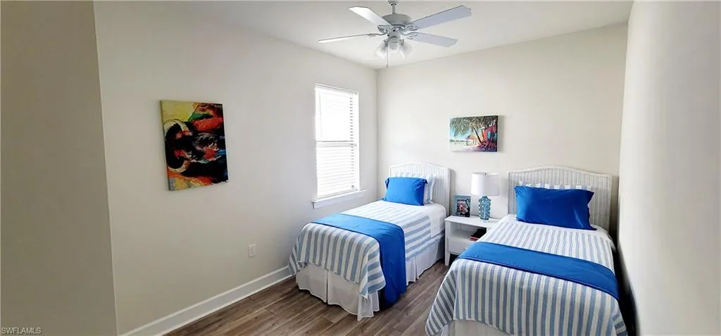 Bedroom with ceiling fan and dark wood-type flooring
