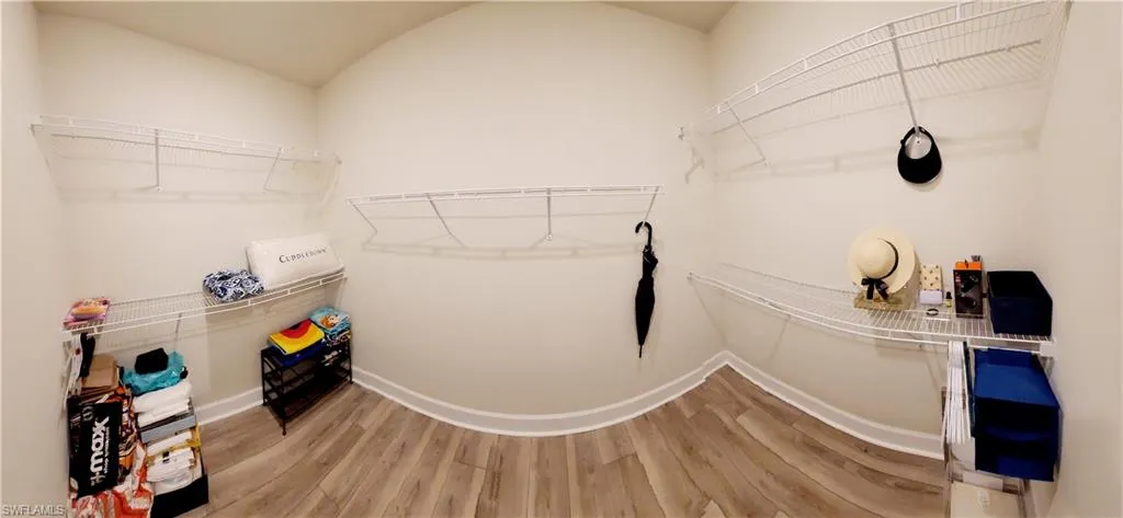 Walk in closet featuring vaulted ceiling and light hardwood / wood-style flooring