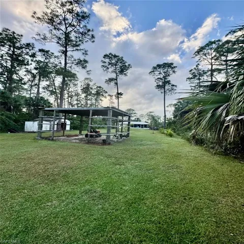 View of yard + oversized shed + pole barn