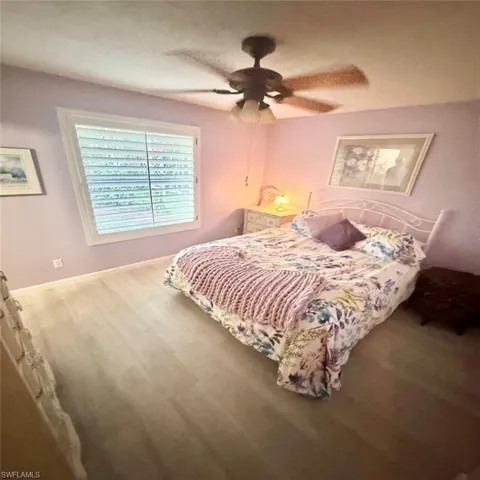 Bedroom featuring hardwood / wood-style flooring, ceiling fan, and a textured ceiling