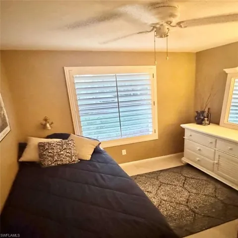 Bedroom featuring ceiling fan and multiple windows
