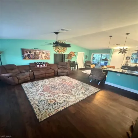 Living room featuring luxury vinyl flooring flooring, lofted ceiling, and ceiling fan