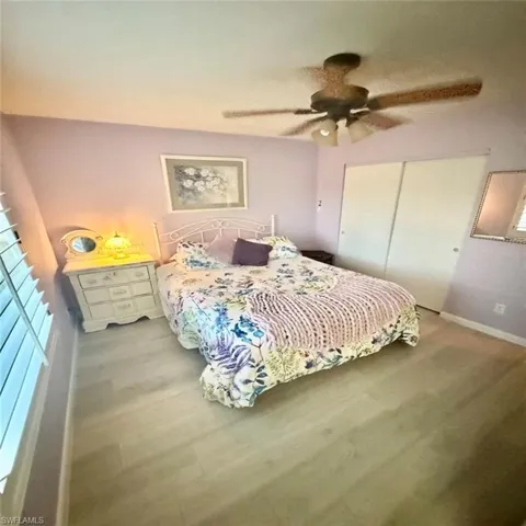 Bedroom featuring hardwood / wood-style floors, ceiling fan, and a closet