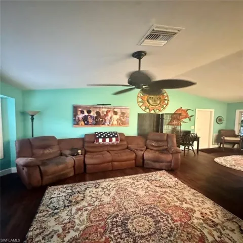 Living room with ceiling fan, and vaulted ceiling