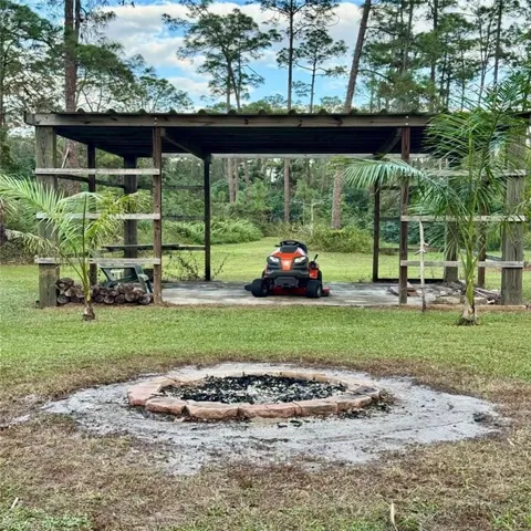 Pole Barn + View of yard with an outdoor fire pit