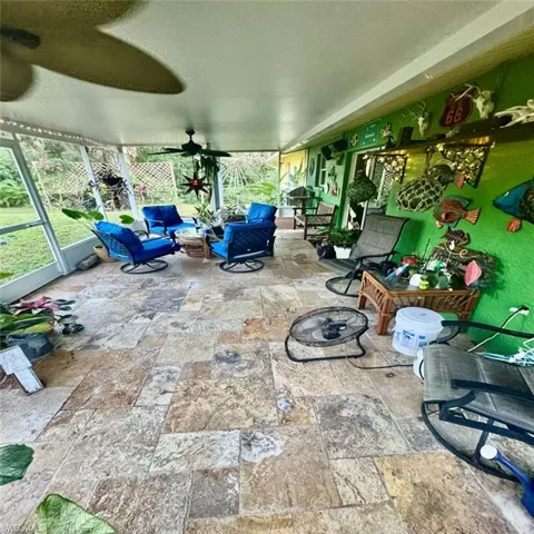 View of patio / terrace featuring ceiling fan, glass enclosure, and an outdoor hangout area