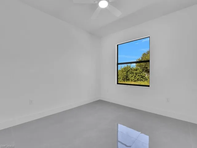 Empty room featuring baseboards and ceiling fan