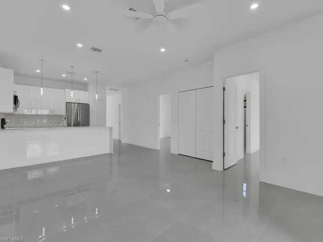 Unfurnished living room featuring recessed lighting, light tile patterned flooring, and ceiling fan