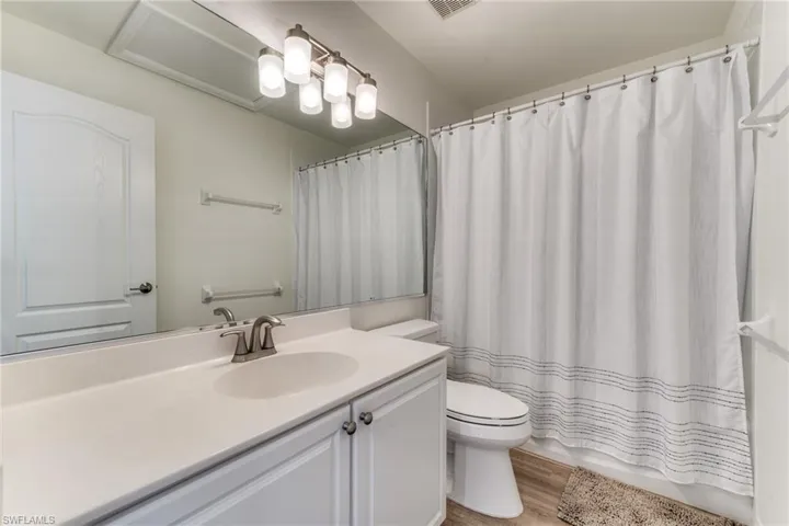 Full bath featuring toilet, wood finished floors, and vanity