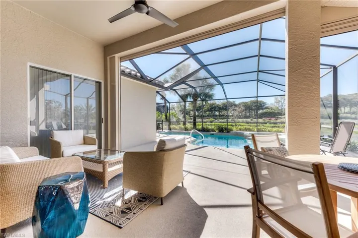 View of patio featuring outdoor lounge area, glass enclosure, an outdoor pool, and a ceiling fan