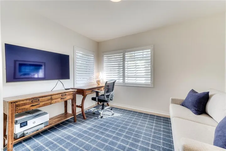 Office area with dark colored carpet and baseboards