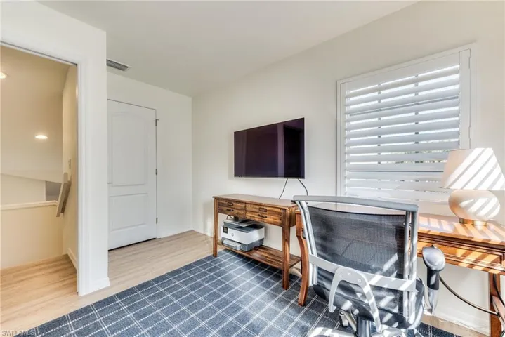Office featuring dark wood-style floors, baseboards, and visible vents
