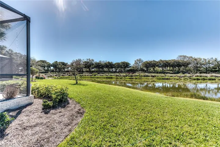 View of yard with glass enclosure and a water view