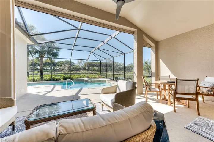 View of patio with outdoor dining area, glass enclosure, ceiling fan, and an outdoor living space