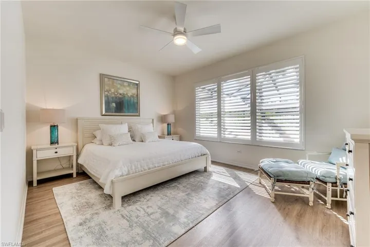 Bedroom with light wood-style flooring, baseboards, and a ceiling fan