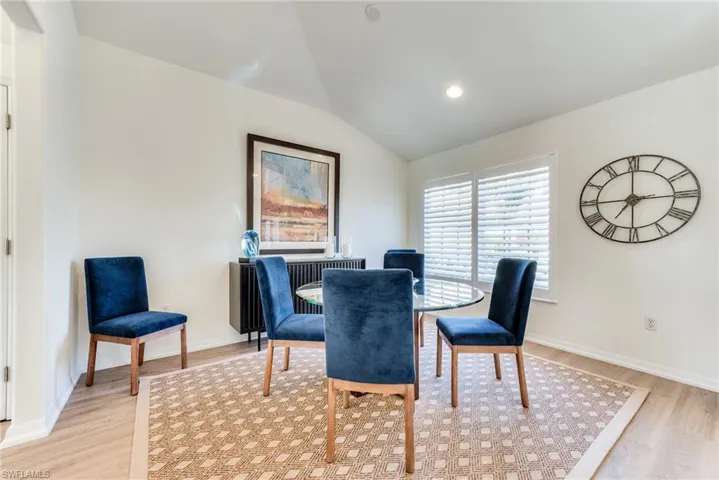 Dining room featuring light wood-style floors, lofted ceiling, baseboards, and recessed lighting