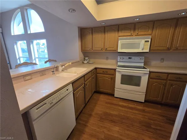 Wood cabinets, corian counter-tops, white appliances.