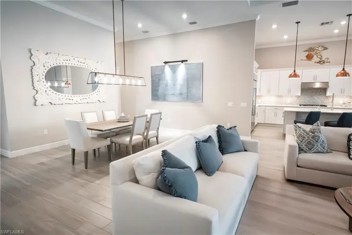 Living room with light hardwood / wood-style floors and ornamental molding