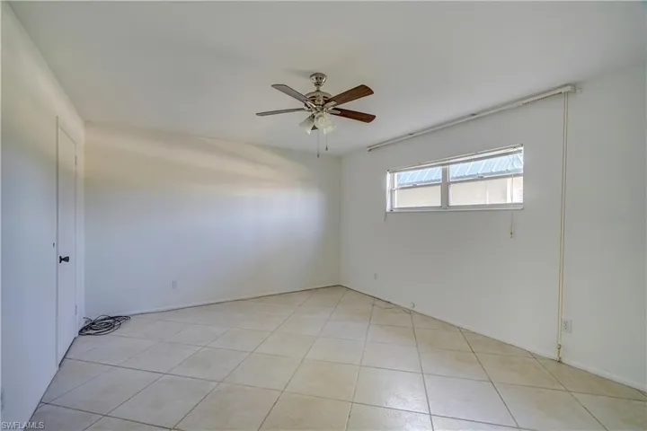 Unfurnished room featuring light tile patterned floors and ceiling fan