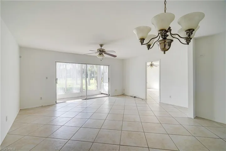 Tiled spare room featuring ceiling fan