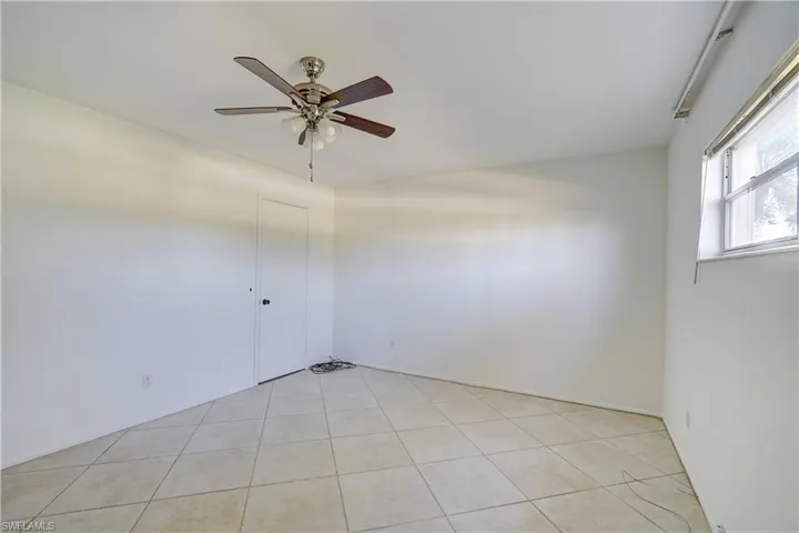 Tiled spare room with ceiling fan