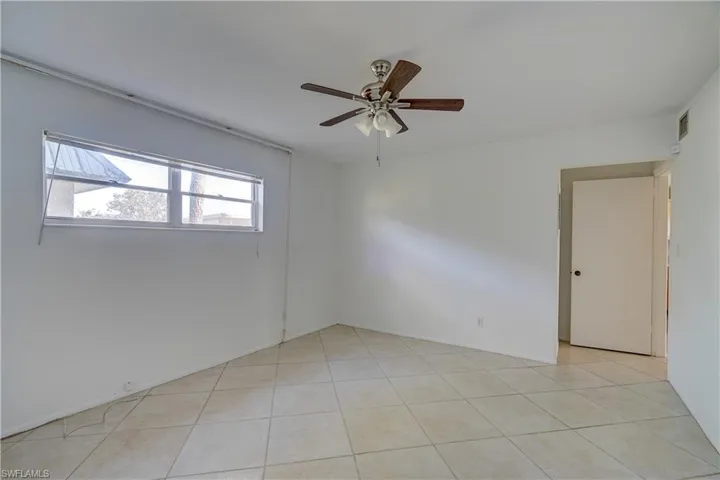 Unfurnished room featuring light tile patterned floors and ceiling fan