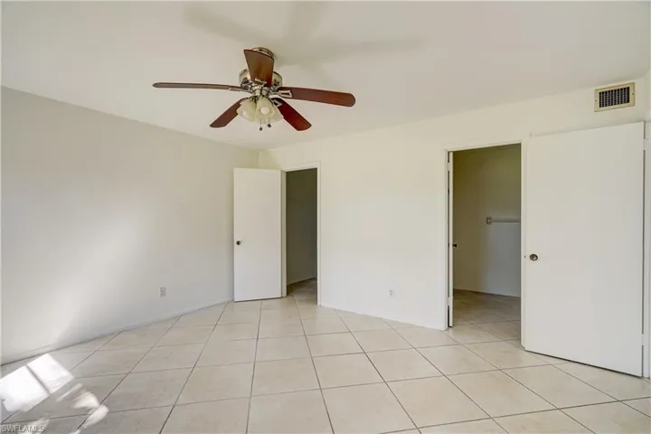 Tiled spare room with ceiling fan