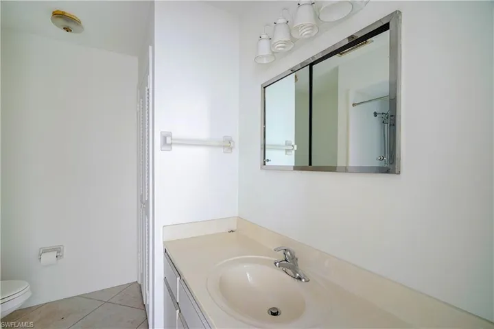 Bathroom with vanity, toilet, and tile patterned flooring