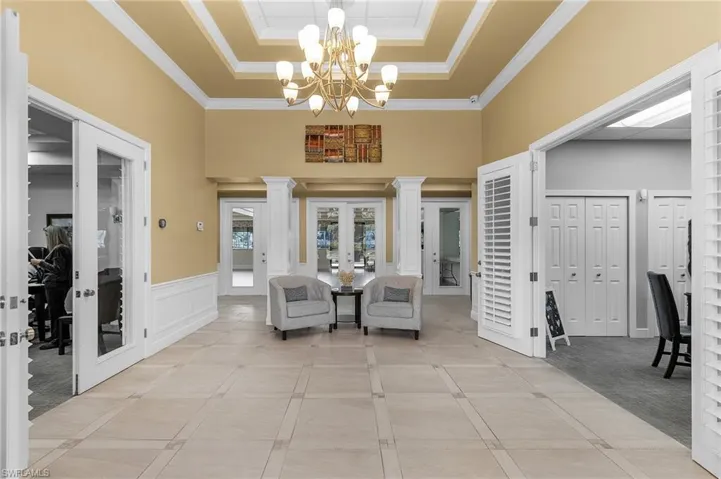 Living area featuring ornamental molding, french doors, and a raised ceiling