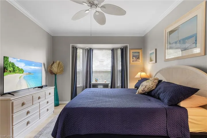 Bedroom featuring ceiling fan, ornamental molding, and light wood-type flooring