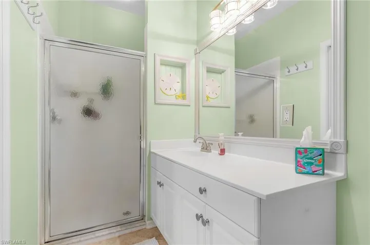 Bathroom with tile patterned flooring, vanity, and an enclosed shower