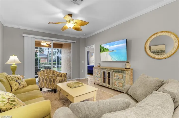 Living room featuring ornamental molding and ceiling fan