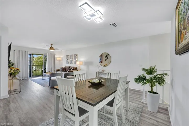 Dining space featuring light wood-type flooring, a ceiling fan, and a textured ceiling