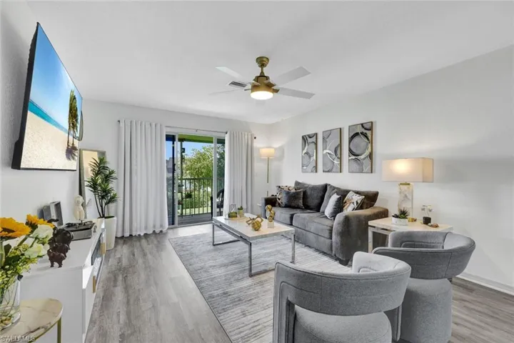 Living room featuring a ceiling fan and light wood-style flooring