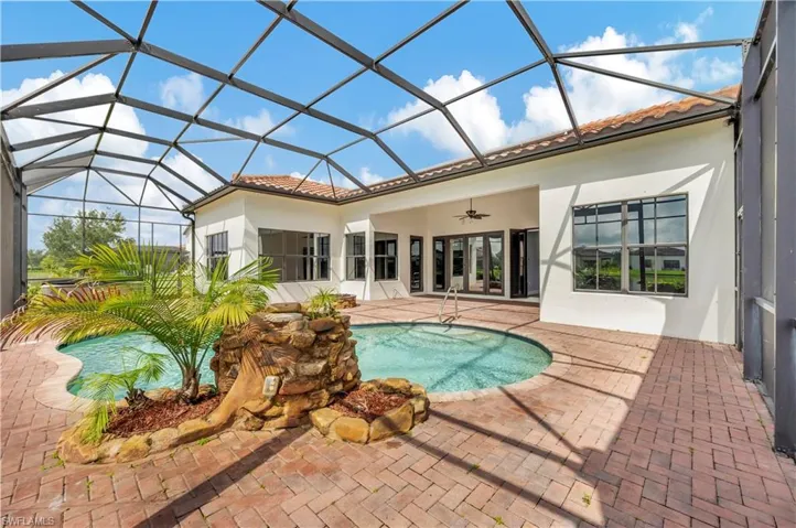 View of swimming pool featuring ceiling fan, a lanai, and a patio