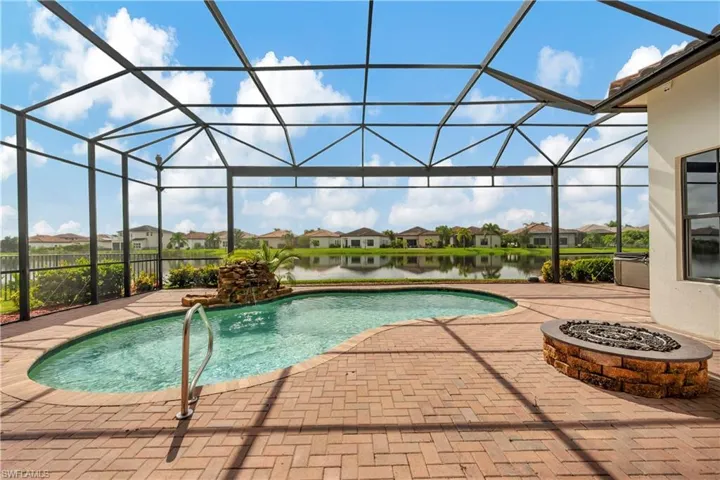 View of swimming pool with a water view, a patio area, and glass enclosure