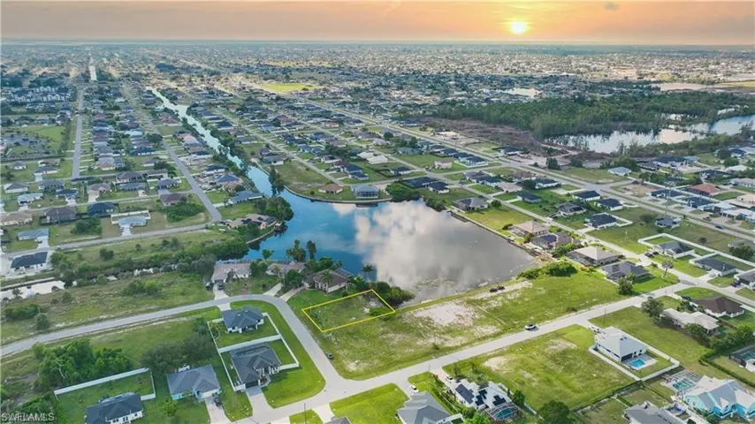Aerial view of property and surrounding area with a nearby body of water and nearby suburban area