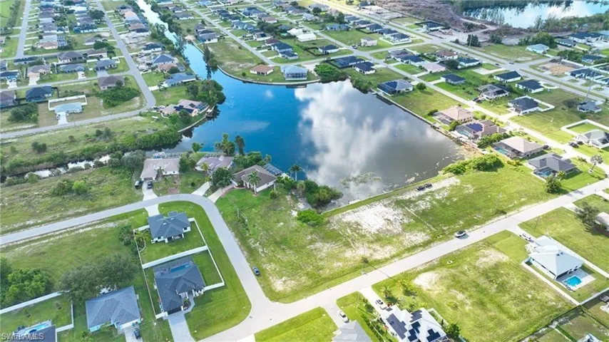Aerial view of property and surrounding area with a nearby body of water and nearby suburban area