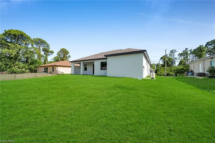 Rear view of property featuring stucco siding and a shingled roof