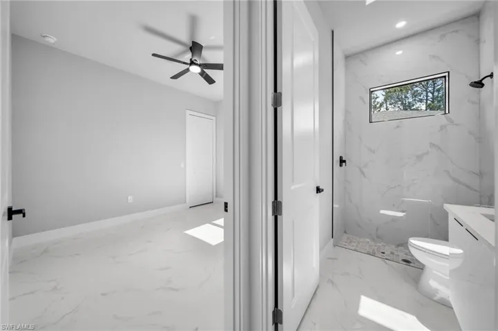 Full bathroom featuring light marble finish flooring, a marble finish shower, vanity, a ceiling fan, and recessed lighting