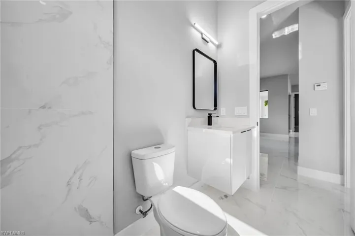 Bathroom with vanity and light marble finish flooring