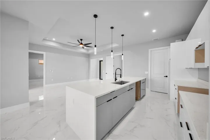 Kitchen with white cabinetry, recessed lighting, ceiling fan, and hanging light fixtures