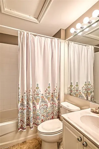 Bathroom with vanity, shower / tub combo with curtain, and tile patterned flooring