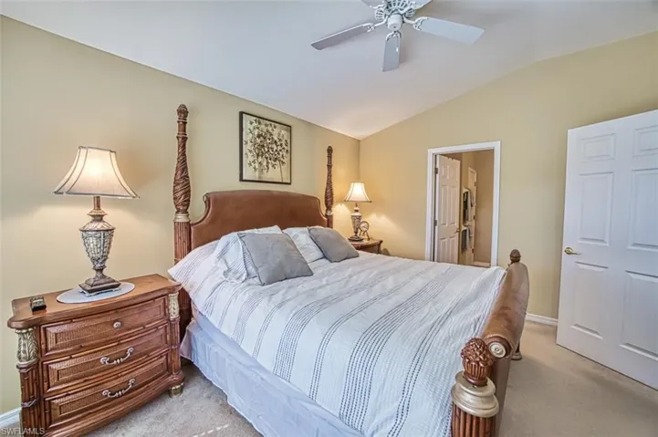 Bedroom featuring lofted ceiling, light colored carpet, and ceiling fan