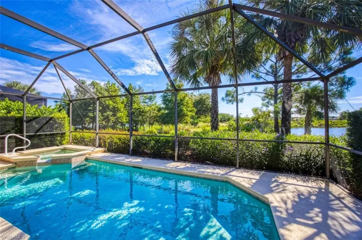 View of swimming pool featuring a sunroom, a lanai, and a pool with connected hot tub