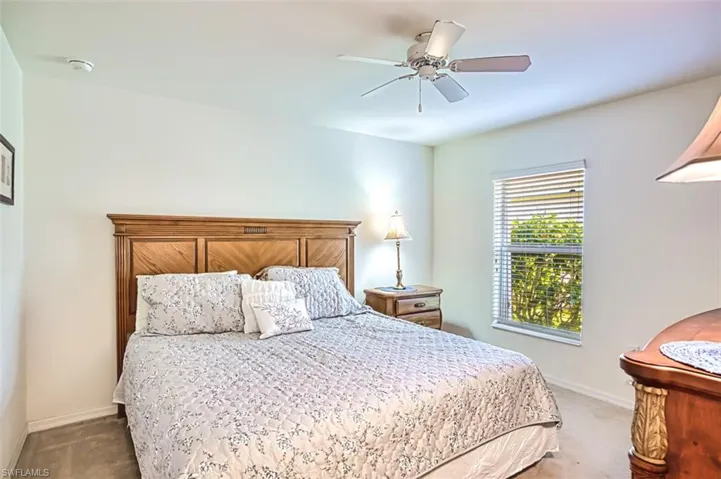 Carpeted bedroom featuring ceiling fan and baseboards